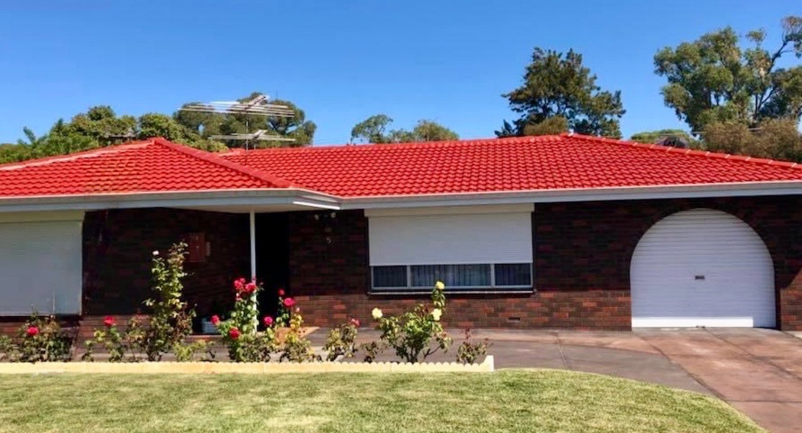 Aged red tile roof restored to a deep finish