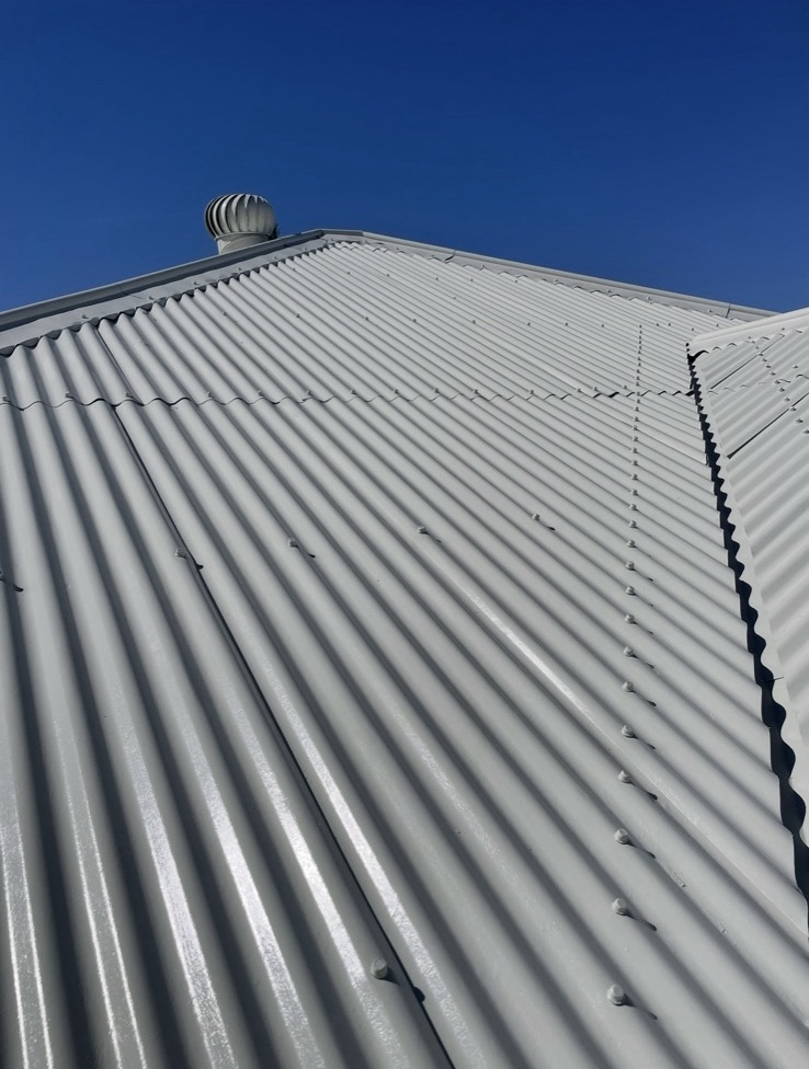 Iron roof restored to a clean white finish